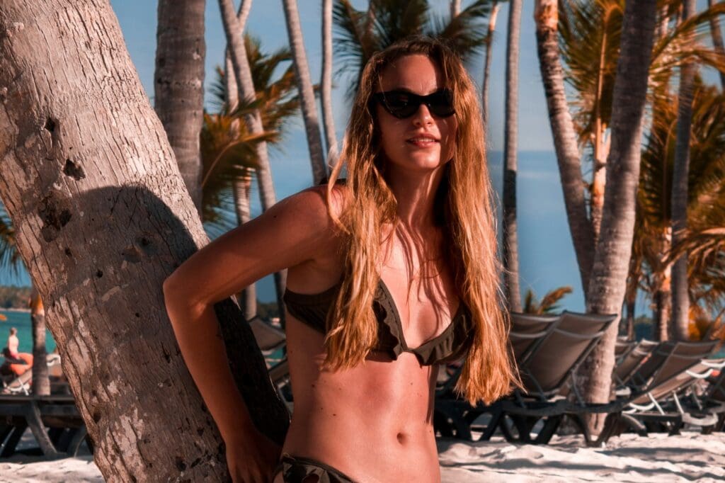 A woman in a bikini standing on the beach.